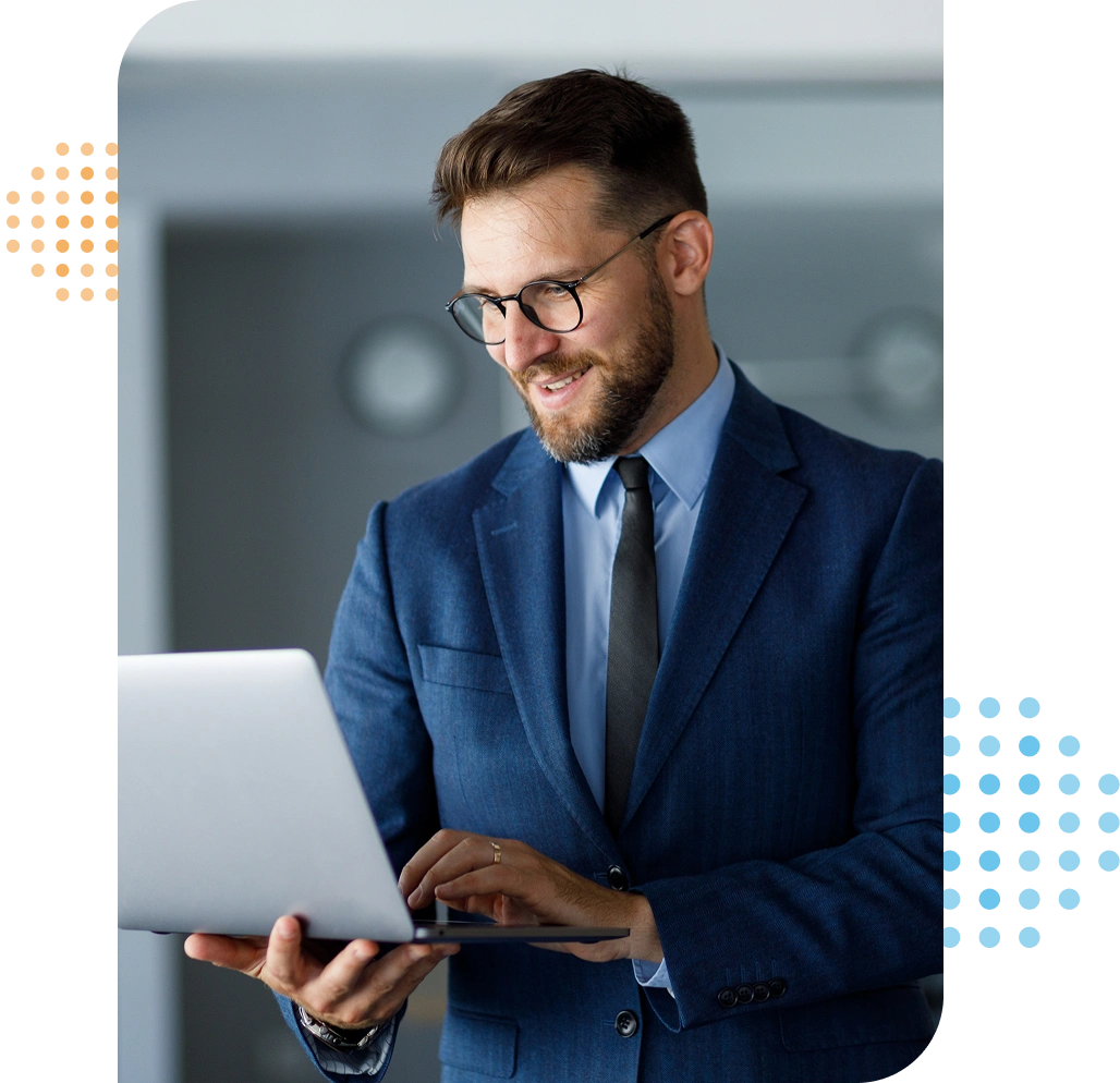 smiling man in a suit holding a laptop